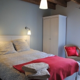 La chambre rouge à l'étage avec lit double