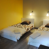 La chambre jaune à l'étage avec deux lits simples